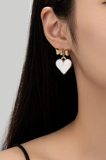 Two tone puffy heart and bow drop earrings.